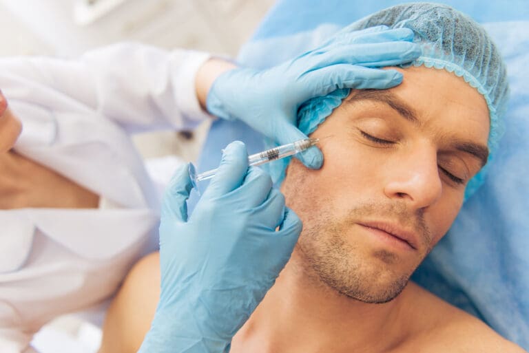 Portrait of man getting an injection in face, lying with closed eyes