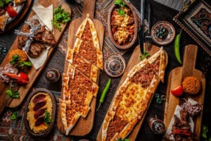 Traditional Turkish cuisine. Pizza, pita, pidesi, sucuk, hummus, kebab, bulgar. Many dishes on the table. Serving dishes in restaurant. Background image. Top view, flat lay