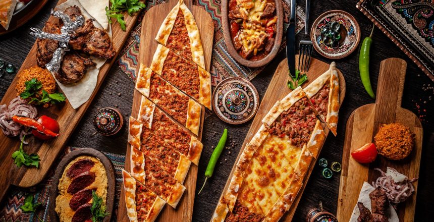 Traditional Turkish cuisine. Pizza, pita, pidesi, sucuk, hummus, kebab, bulgar. Many dishes on the table. Serving dishes in restaurant. Background image. Top view, flat lay